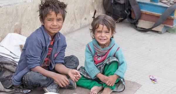 Two Indian boys sitting on the ground, representing a transformative journey sparked by Alan Stevens' profiling expertise