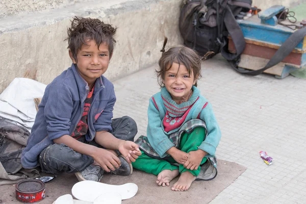 Two Indian boys sitting on the ground, representing a transformative journey sparked by Alan Stevens' profiling expertise